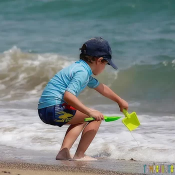 dicas-de-estimulo-sensorial-e-fisico-nas-brincadeiras-na-praia-menino-brincando-na-praia