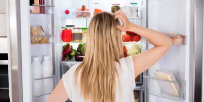 Rear,View,Of,Young,Woman,Looking,In,Fridge,At,Kitchen